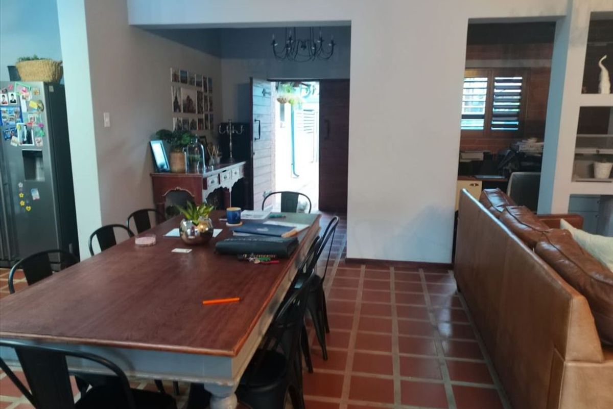Open plan living and dining area featuring terracotta tile flooring and neutral wall finishes, providing a versatile space for family living.