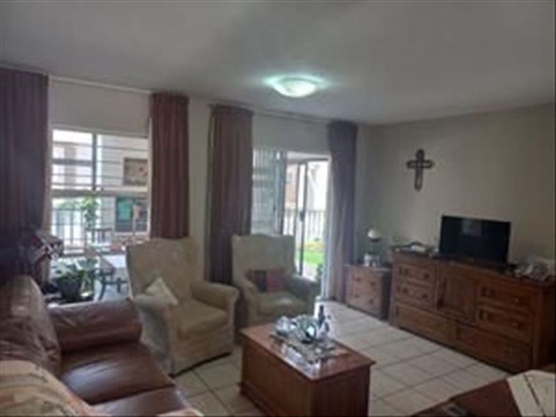 A comfortable living room featuring tiled flooring and sliding glass doors that provide access to the outdoor area.