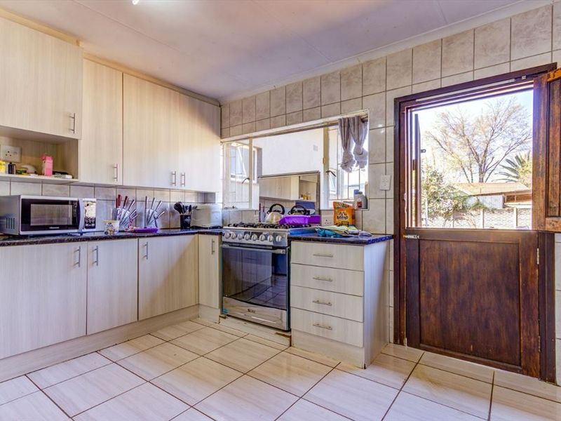 A functional kitchen featuring laminate cabinetry, granite countertops, a gas stove, and direct access to the exterior via a stable door.
