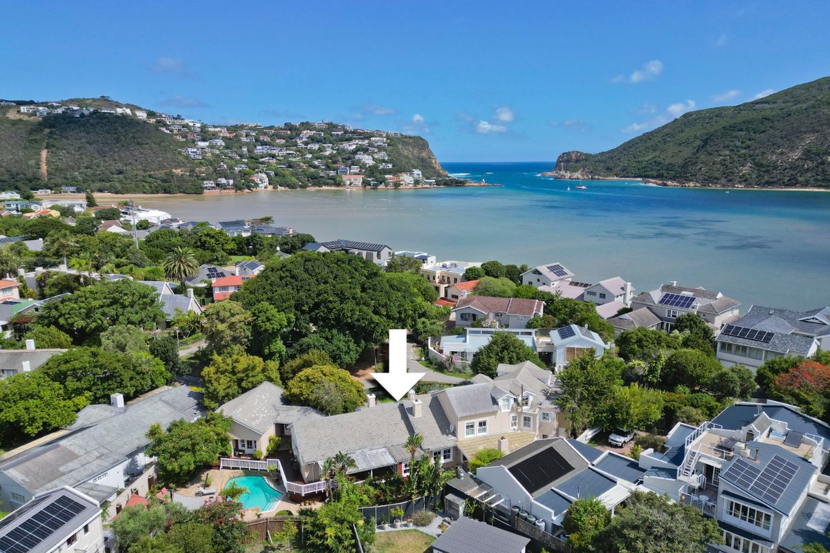 Aerial view of a coastal residential property featuring a swimming pool, solar panels, and proximity to the lagoon and ocean.