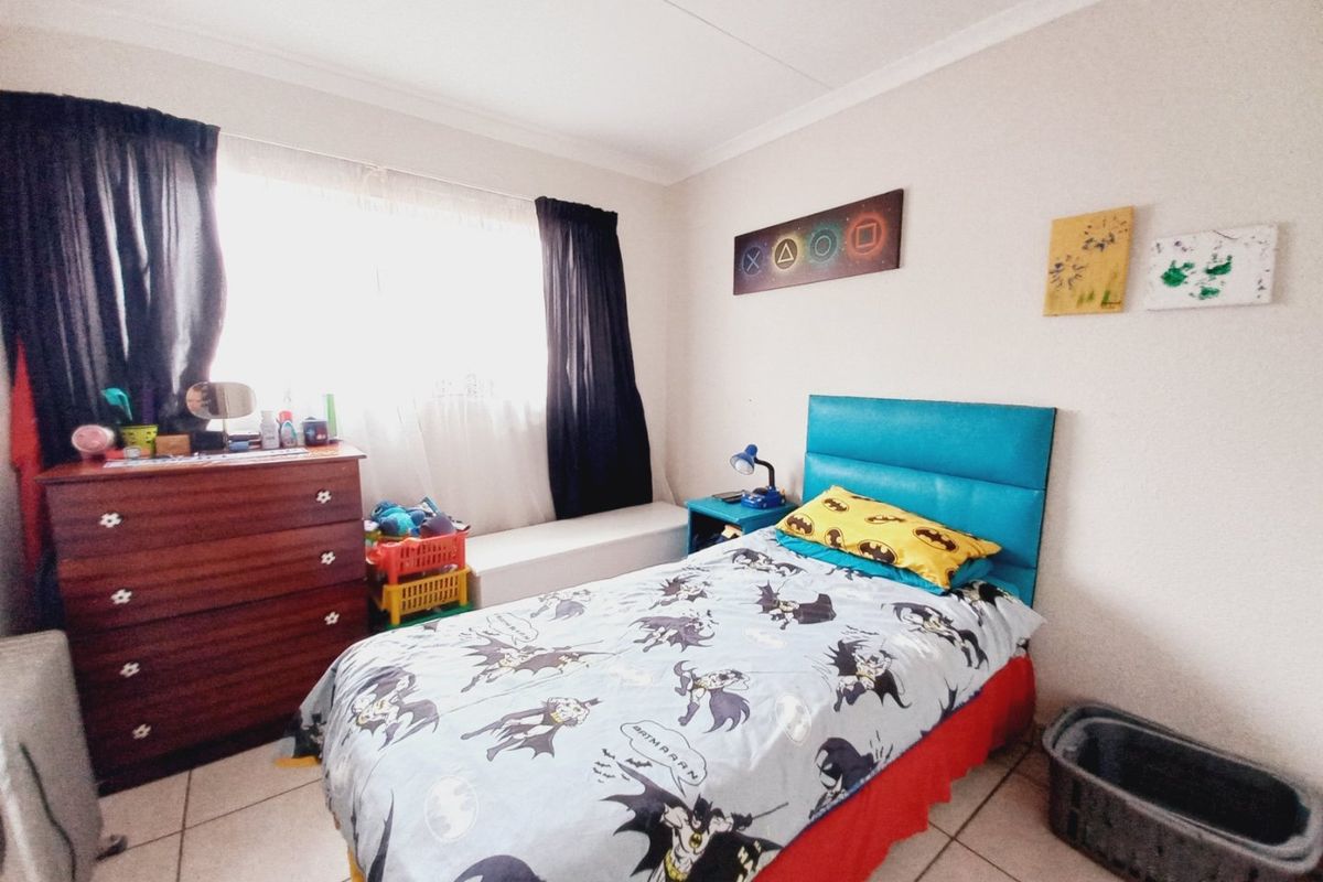 A bedroom featuring tiled flooring and a large window with curtain tracks.