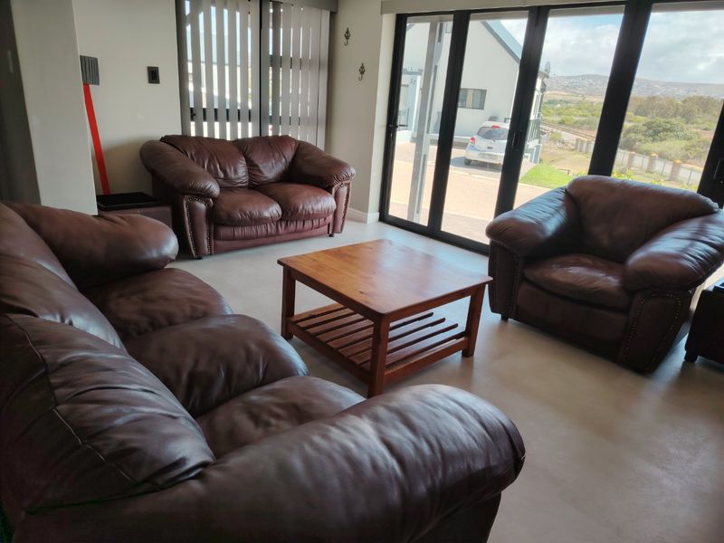 A bright living room featuring tiled flooring and large sliding glass doors that provide natural light and access to the exterior.