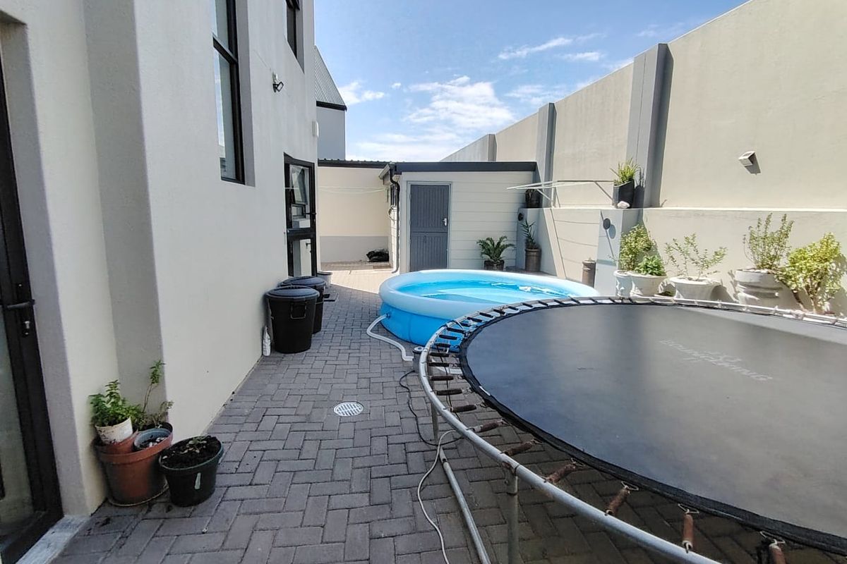 A paved rear courtyard area featuring high boundary walls, providing a private outdoor space accessible from the main dwelling.