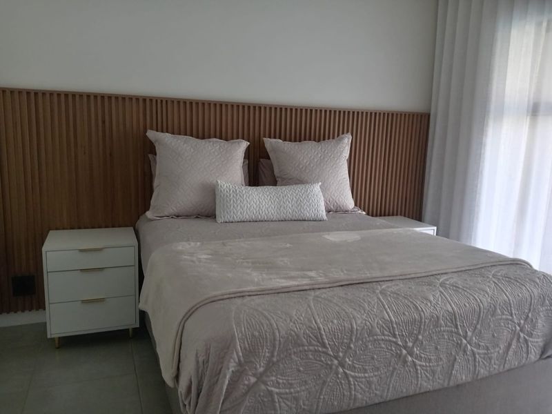 A well-maintained bedroom featuring a modern timber slat feature wall and floor-to-ceiling curtains, creating a warm and inviting atmosphere.