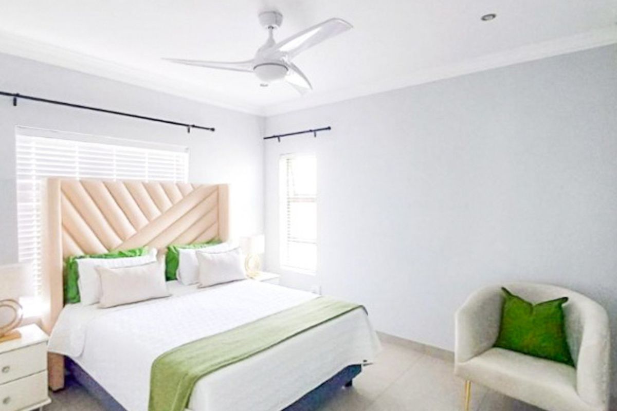 A bright and well-maintained bedroom featuring tiled flooring, recessed lighting, a modern ceiling fan, and venetian blinds.