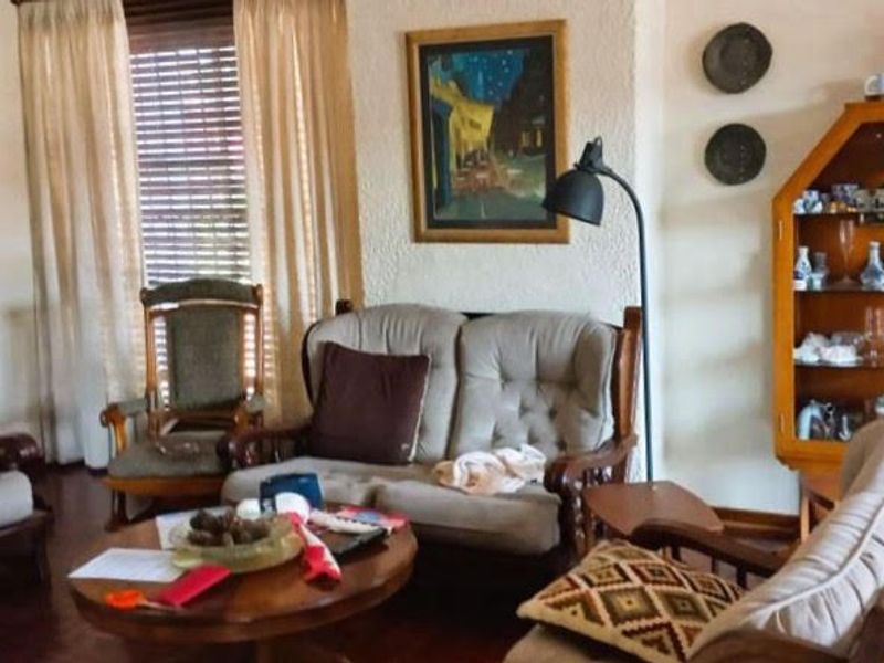 A traditional living room featuring textured wall finishes and hardwood flooring, offering a comfortable and classic living space.