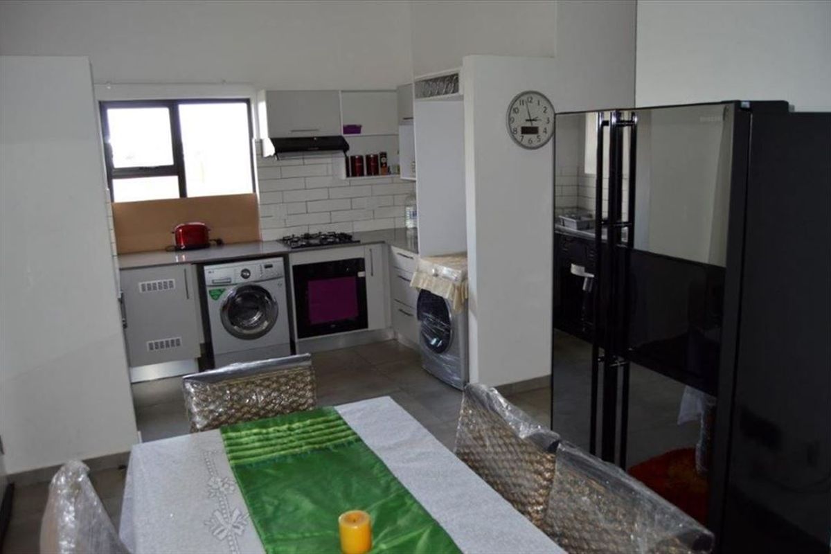 A functional kitchen featuring built-in cabinetry, a gas hob, an integrated oven, and a subway tile backsplash, with tiled flooring throughout.