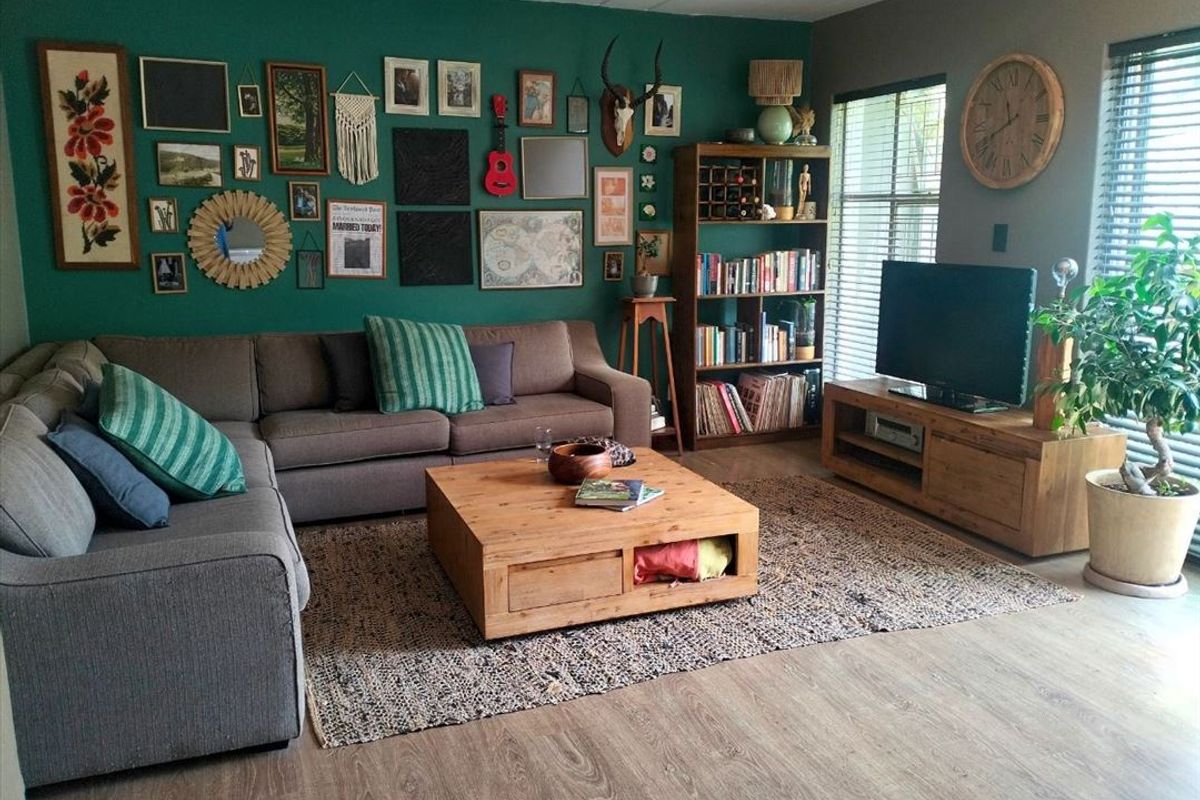 A comfortable living room featuring laminate flooring and venetian blinds, creating a cozy and inviting space for relaxation.