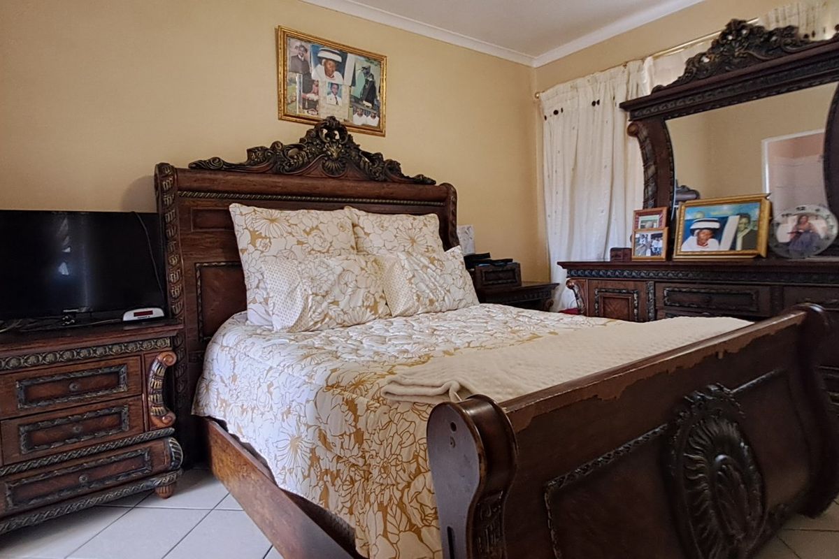 A bedroom featuring tiled flooring and neutral wall finishes, providing a functional space for rest.