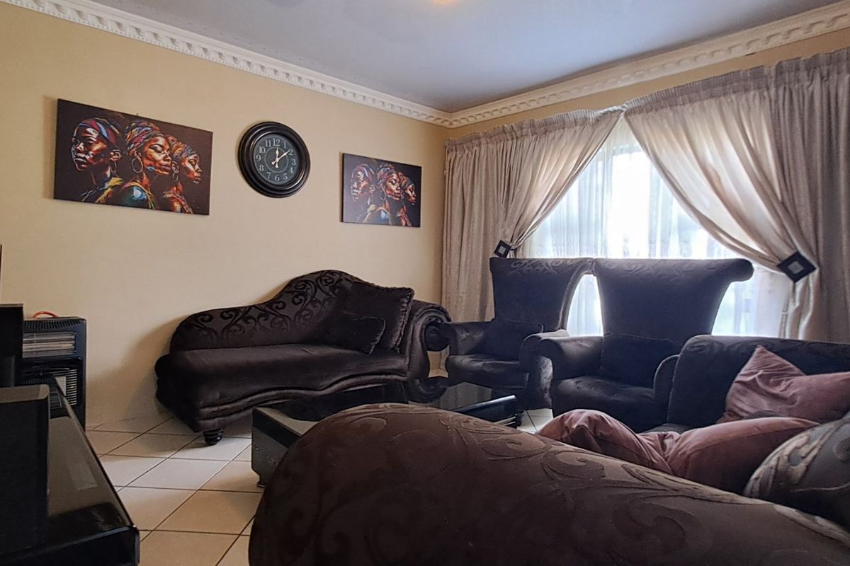 A living room featuring tiled flooring and decorative crown molding, providing a functional and comfortable space for relaxation.
