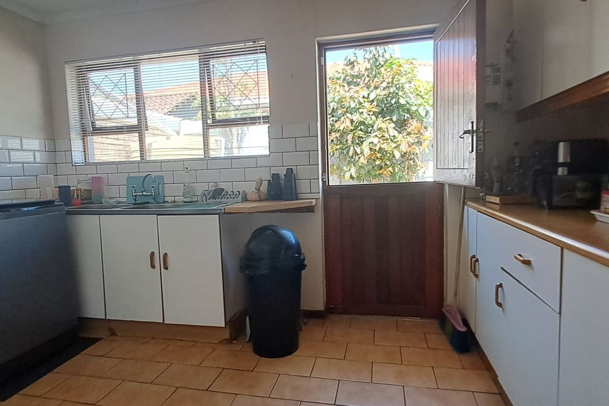 Functional kitchen featuring subway tile backsplash, laminate countertops, and direct access to the rear exterior via a stable door.