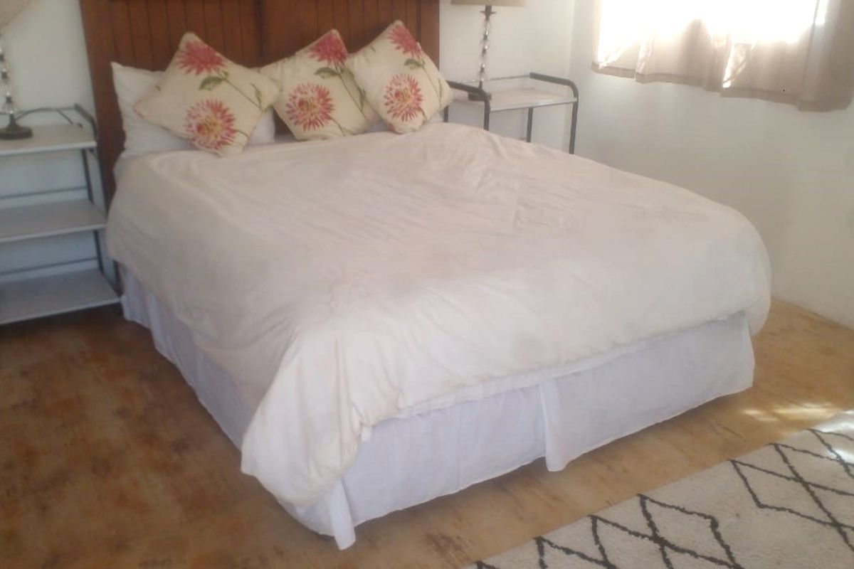 A bedroom featuring a wooden headboard and light-toned flooring, providing a functional space for rest.