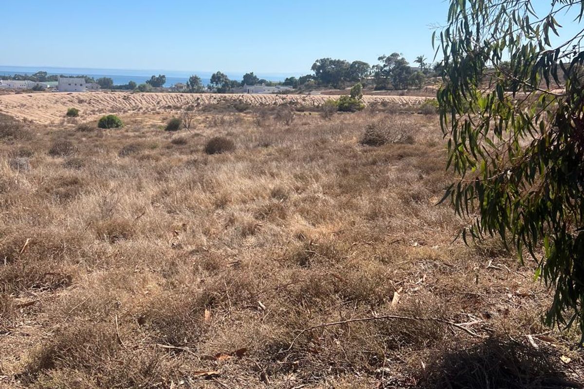 A view of the vacant residential land with distant coastal scenery and natural vegetation.