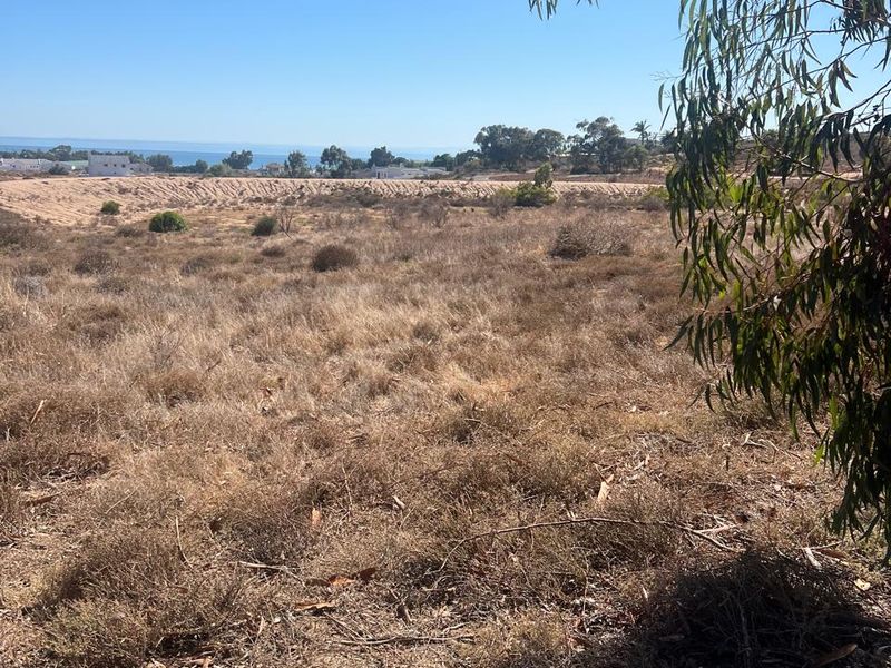 A view of the vacant residential land with distant coastal scenery and natural vegetation.
