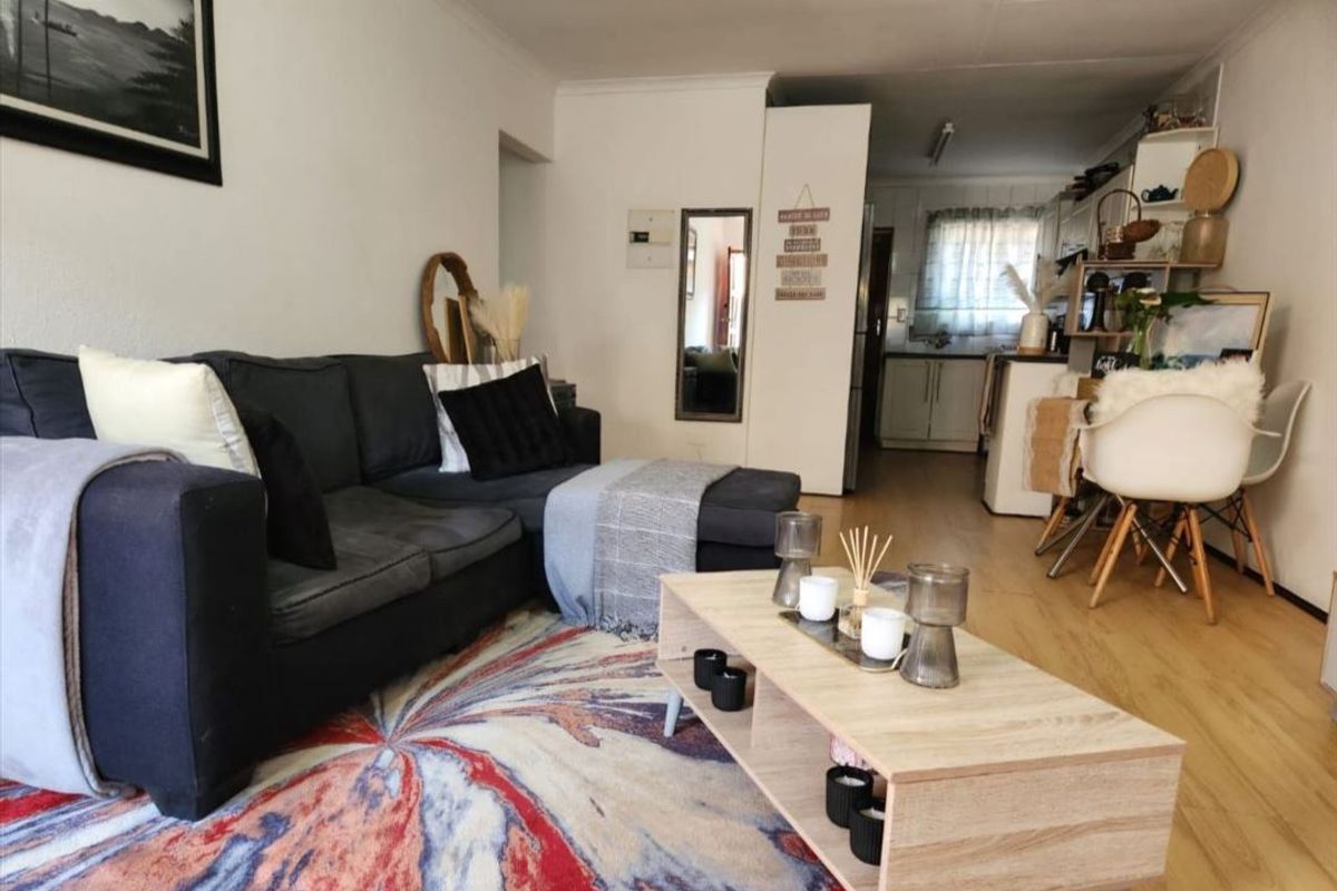 Open plan living area featuring light wood-look flooring and a seamless transition into the kitchen space.