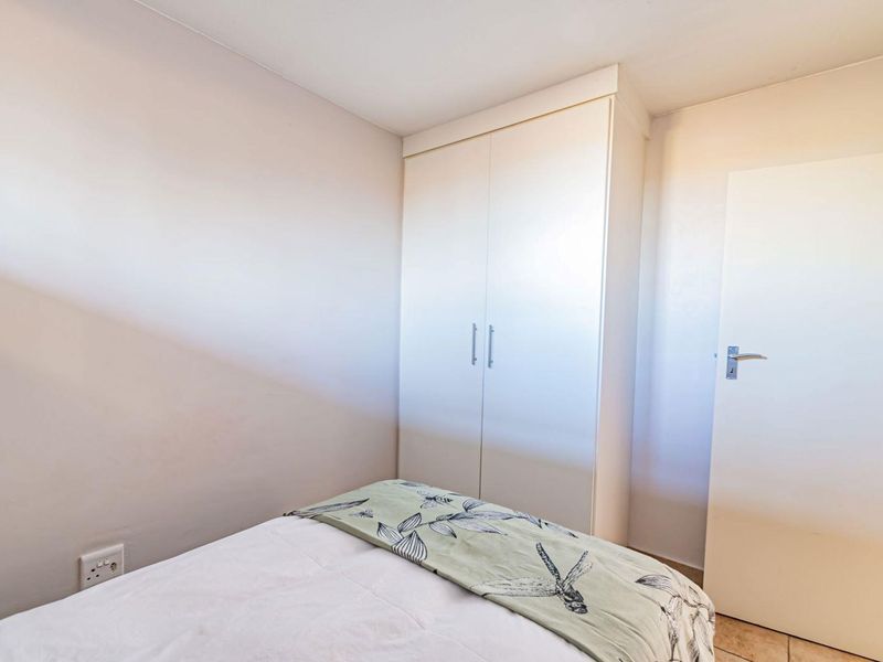 A clean bedroom featuring a built-in wardrobe and neutral wall finishes, providing a functional and well-maintained living space.