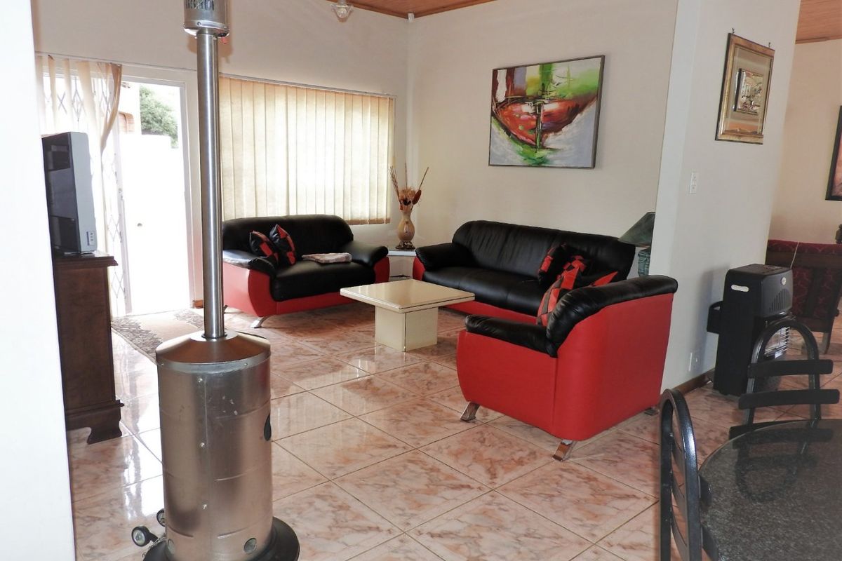 Spacious living area featuring tiled flooring and a timber ceiling, with direct access to the exterior through a sliding glass door.