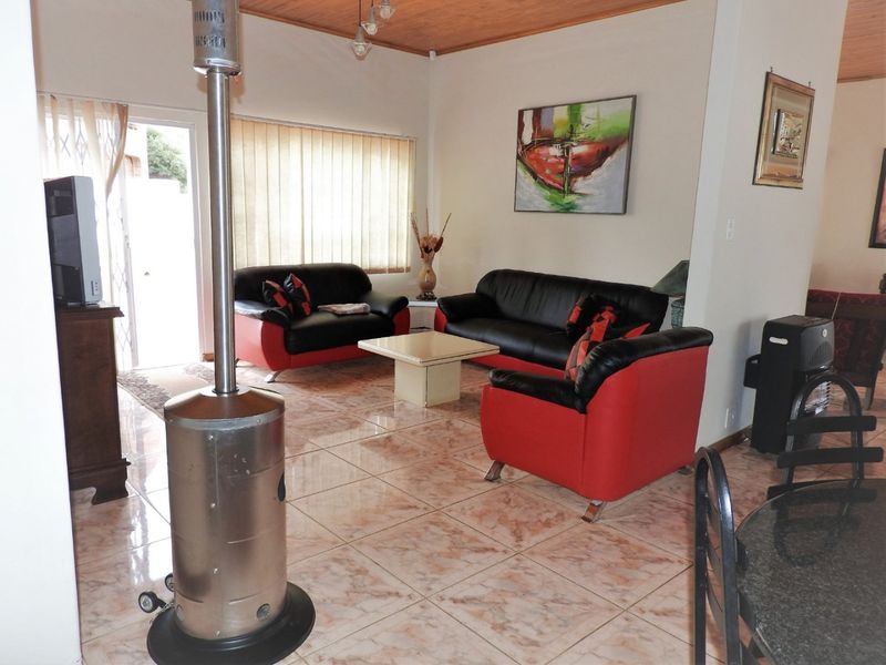 Spacious living area featuring tiled flooring and a timber ceiling, with direct access to the exterior through a sliding glass door.