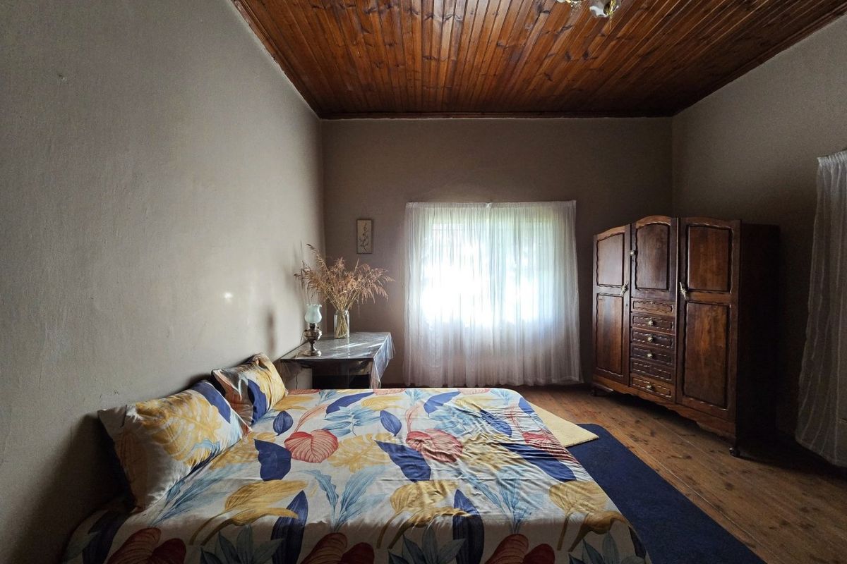 A bedroom featuring rustic timber plank ceilings and original timber flooring, offering a warm and traditional aesthetic.