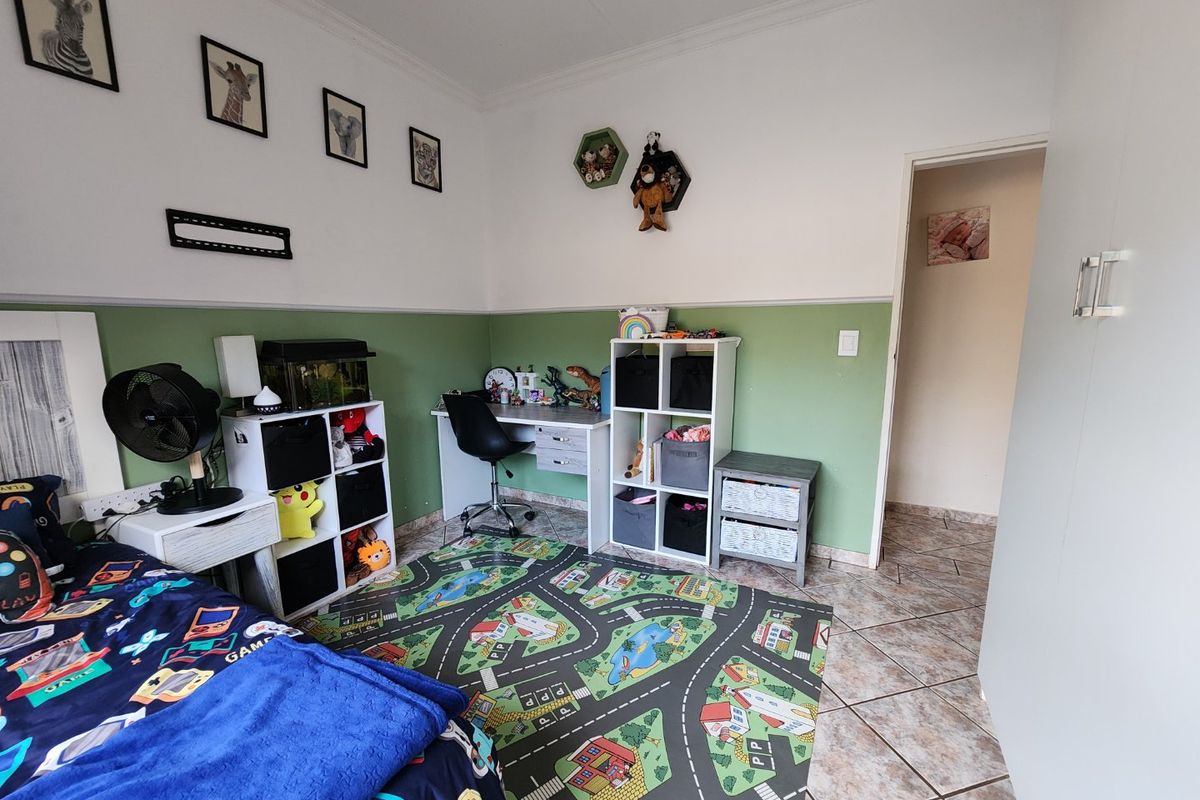 A bedroom featuring tiled flooring, two-tone wall paint, and built-in cupboard storage.