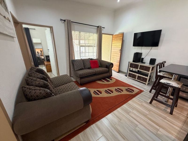 Open plan living area featuring tiled flooring and direct access to an exterior door.