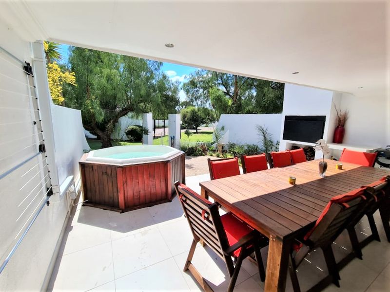 Covered outdoor patio featuring tiled flooring, recessed lighting, a built-in fireplace, and direct access to the garden area.
