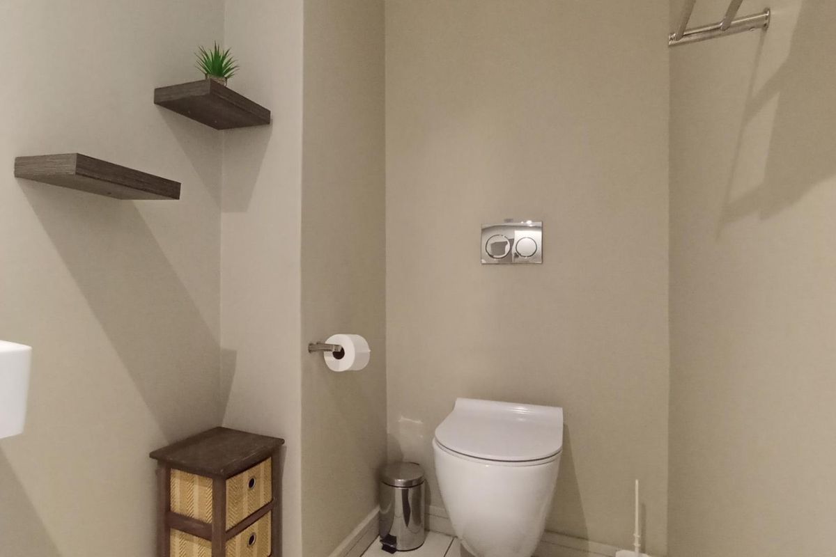 A modern bathroom featuring a wall-mounted toilet with a dual-flush system and a wall-mounted basin.