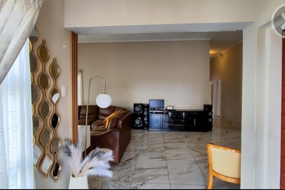 A view into a living area featuring polished marble-look floor tiles and a wide transition between rooms.
