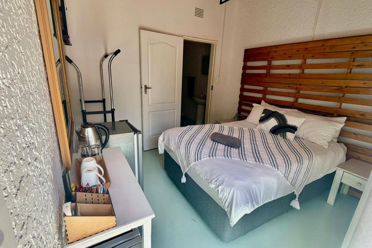 A compact bedroom featuring textured wall finishes and direct access to an en-suite bathroom.