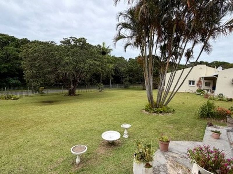 A spacious rear garden featuring a paved patio area, established lawn, and perimeter fencing, providing a private outdoor space for the townhouse.