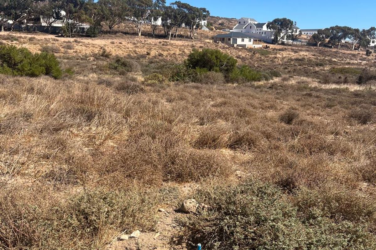 A view of a vacant residential plot featuring natural vegetation and surrounding landscape, suitable for future development.