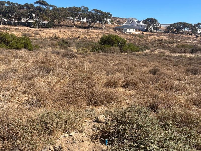 A view of a vacant residential plot featuring natural vegetation and surrounding landscape, suitable for future development.