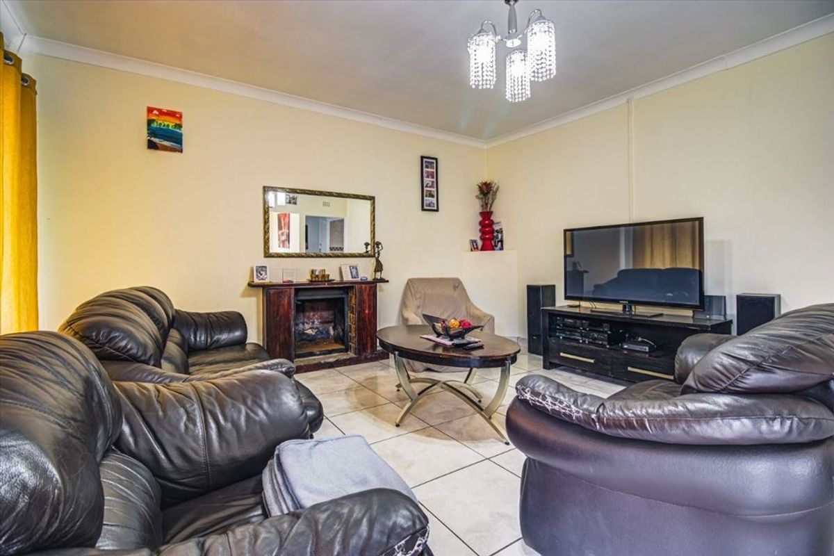 A living room featuring tiled flooring, a fireplace, and decorative ceiling lighting, offering a functional space for relaxation.