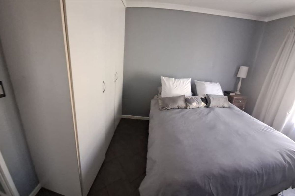 A functional bedroom featuring built-in cupboards and neutral wall finishes, providing a comfortable and practical living space.