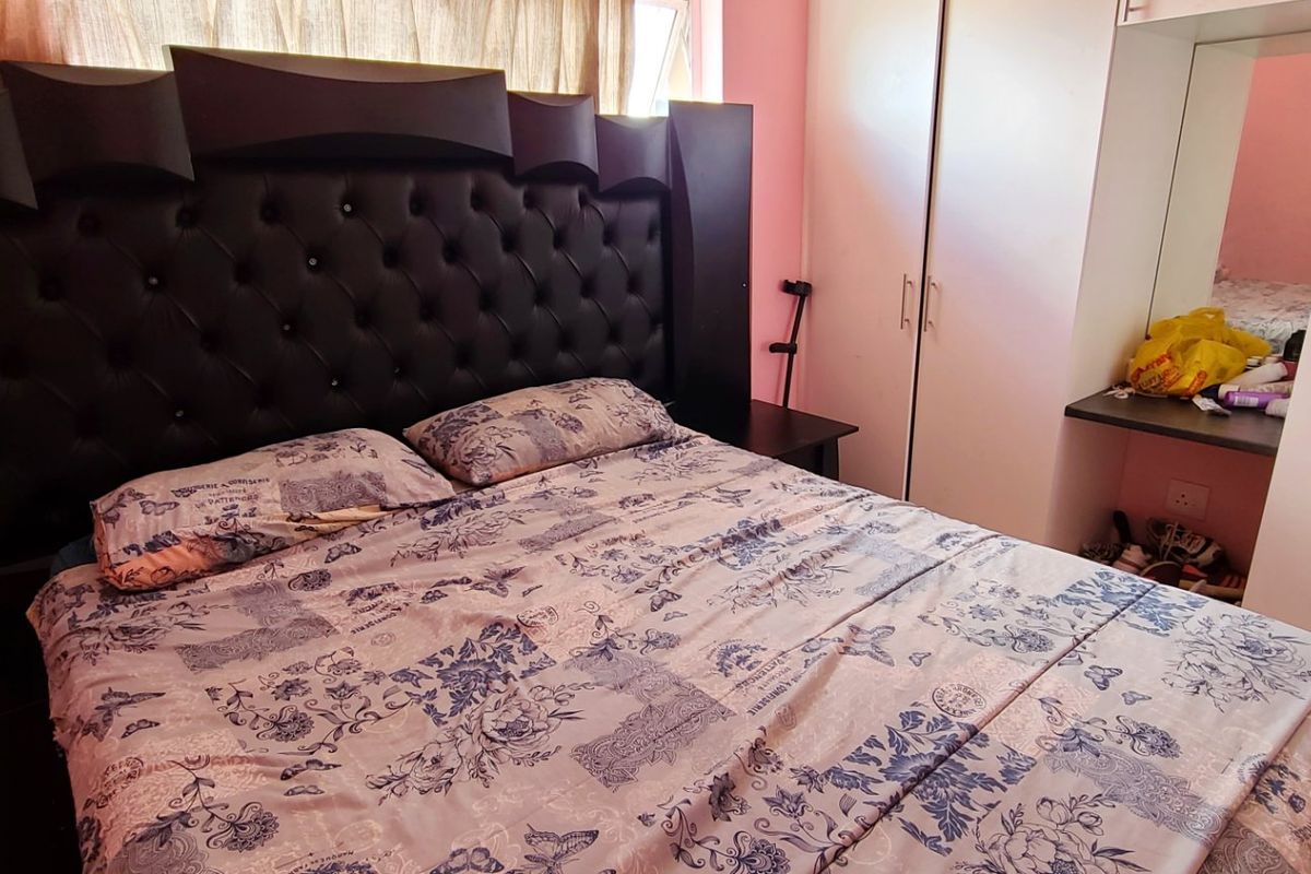 A bedroom featuring built-in cupboards with an integrated vanity area and a window.