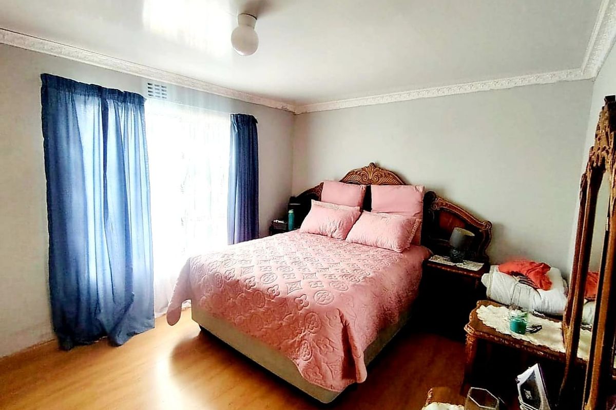 A bedroom featuring laminate flooring and decorative ceiling cornicing, providing a neutral base for personalization.