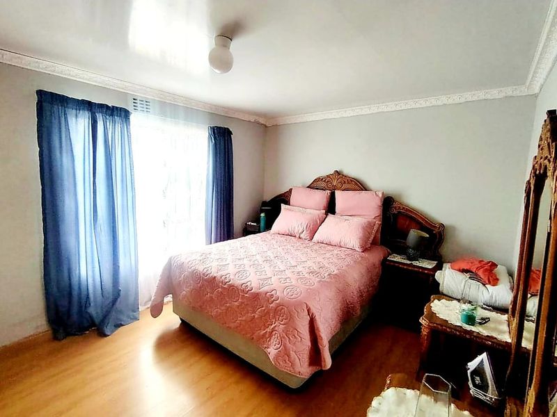 A bedroom featuring laminate flooring and decorative ceiling cornicing, providing a neutral base for personalization.