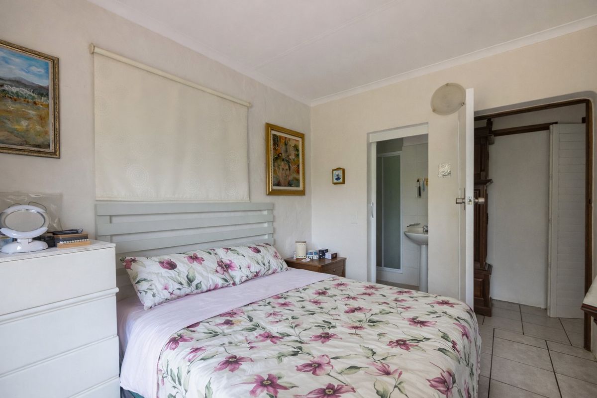 A bedroom featuring tiled flooring and an en-suite bathroom with a pedestal basin.