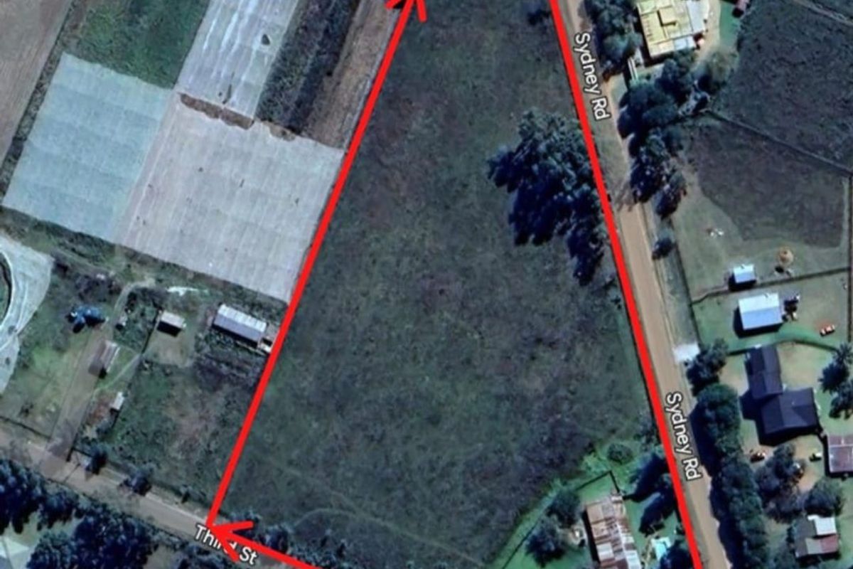 Aerial view of a large triangular corner plot situated at the intersection of Sydney Road and Third Street.
