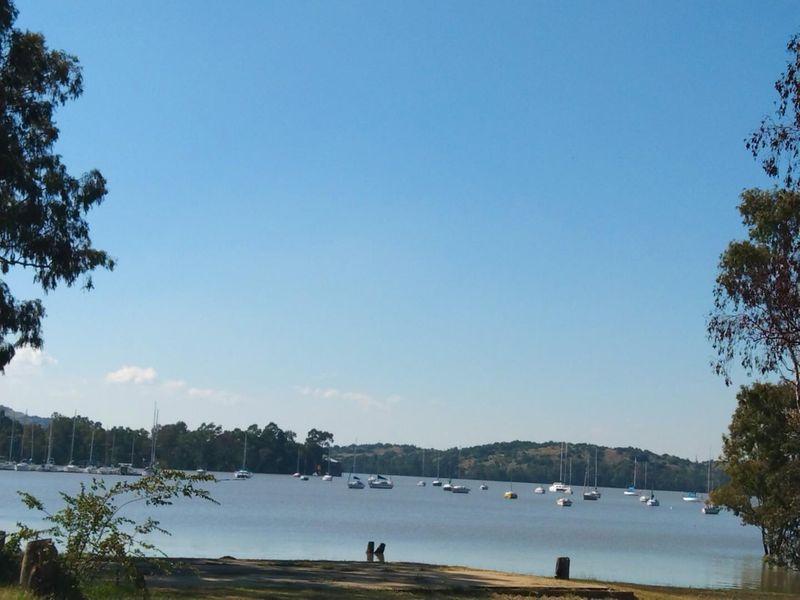 A scenic view of the lake featuring calm waters and distant hills, showcasing the natural landscape surrounding the property.