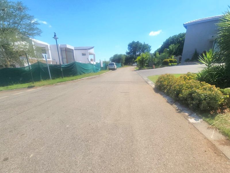 A view of the residential street showing the paved road, verge, and surrounding property access points in a quiet neighborhood setting.