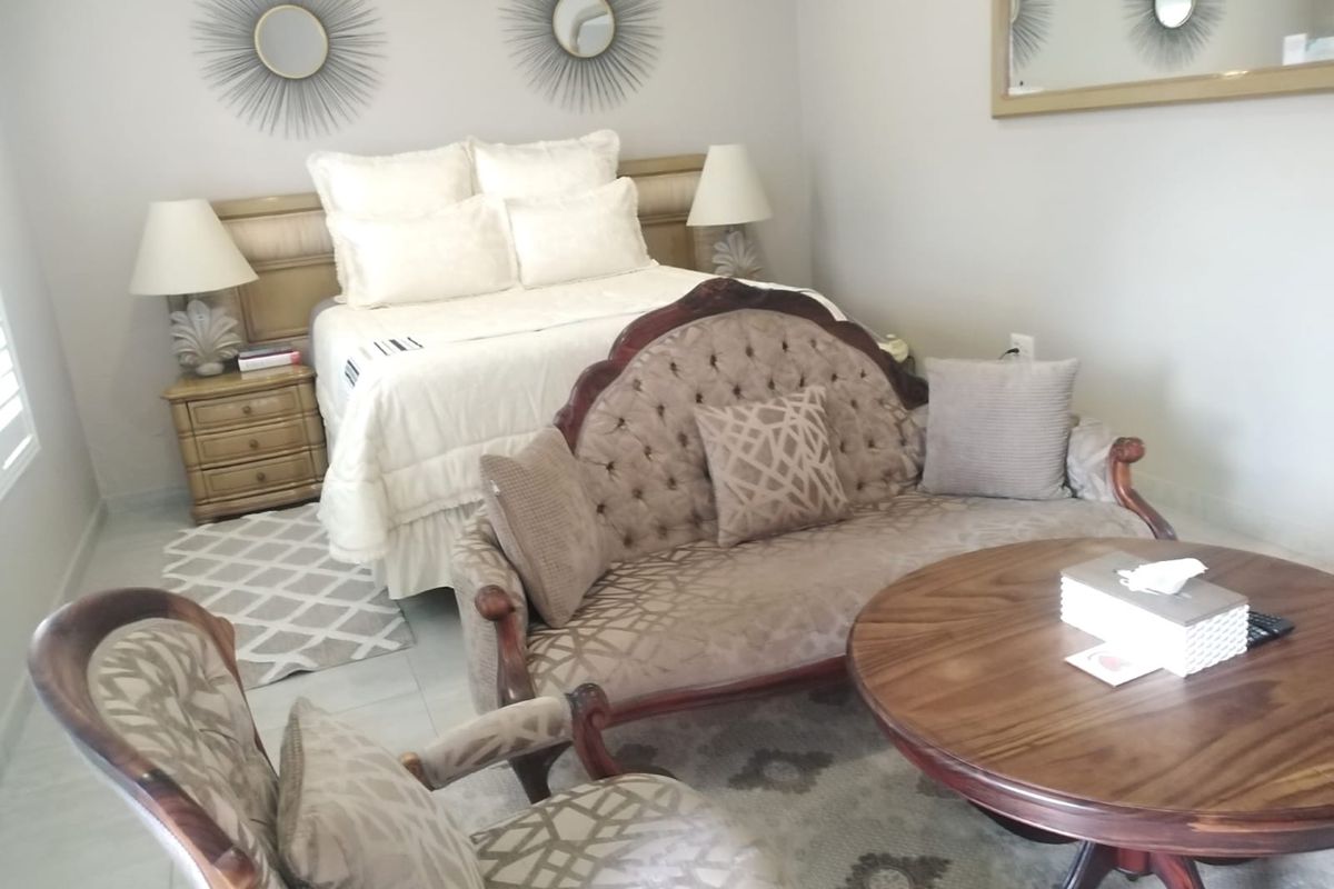 A spacious bedroom featuring tiled flooring and a neutral color palette, providing a comfortable and well-maintained living space.