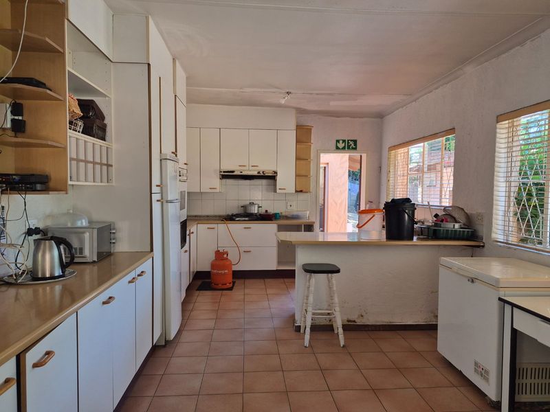 A functional kitchen featuring built-in cabinetry, a breakfast bar, and tiled flooring, offering potential for modernization and cosmetic updates.