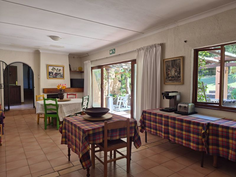 Spacious open-plan living and dining area featuring tiled floors, a fireplace, and large sliding doors providing direct access to the outdoor patio.