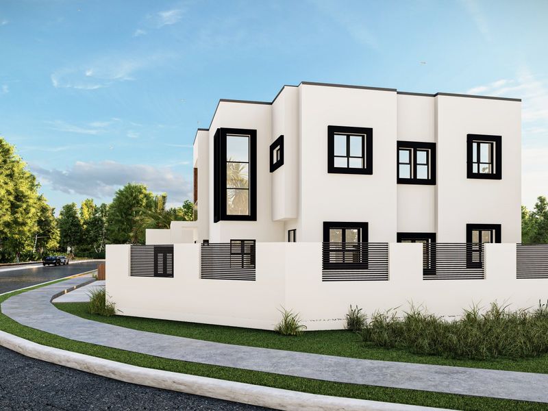 A modern two-story residential property featuring a clean white facade, black window frames, and a contemporary boundary wall with integrated metal fencing.
