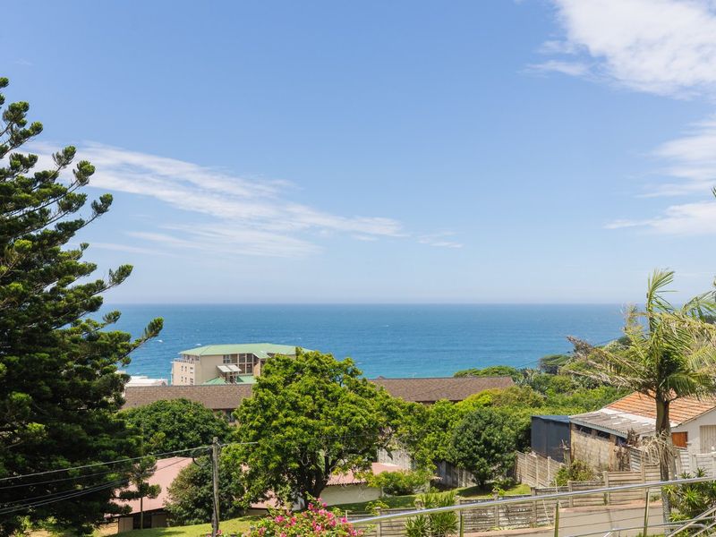A scenic elevated view overlooking the surrounding neighborhood with a clear perspective of the ocean and coastline.