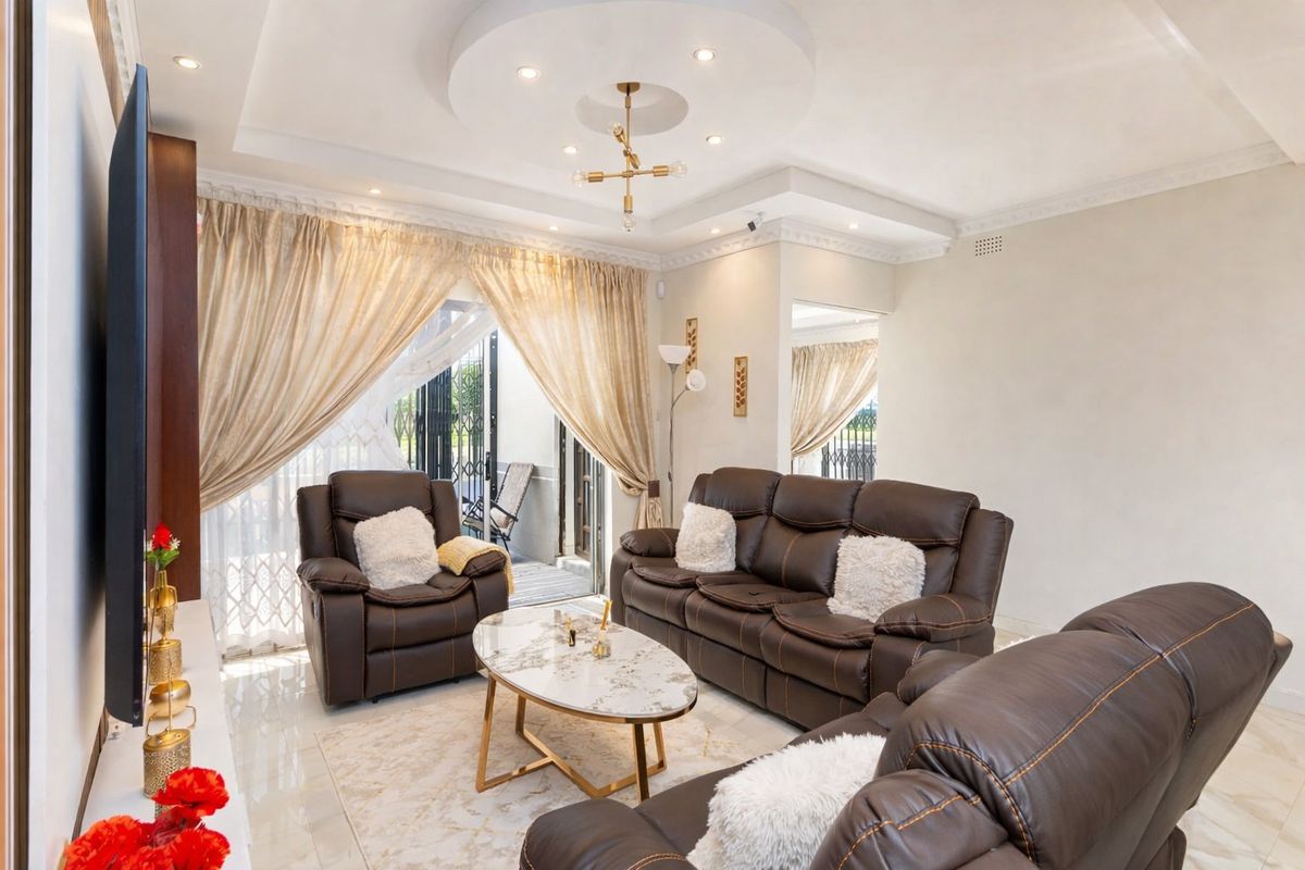 A well-maintained living room featuring a recessed ceiling with downlights, tiled flooring, and sliding glass doors providing access to the outdoor area.