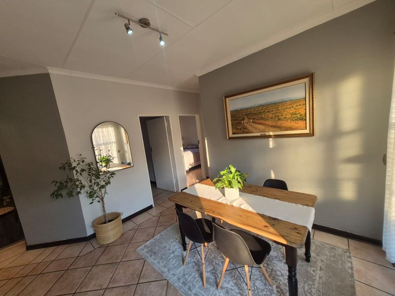 A dining area featuring tiled flooring, coved ceilings, and track lighting, providing a functional space for meals.