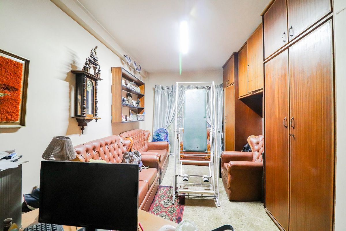 A bedroom featuring extensive built-in wooden cabinetry and wardrobes, providing ample storage space within a functional layout.