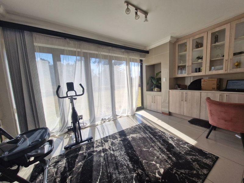 A bright living area featuring built-in cabinetry, tiled floors, and large sliding glass doors that provide ample natural light and access to the outdoors.
